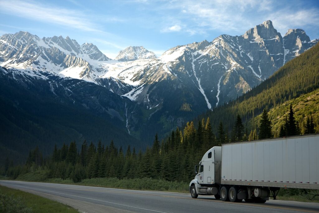 Truck driving through a mountainous landscape.